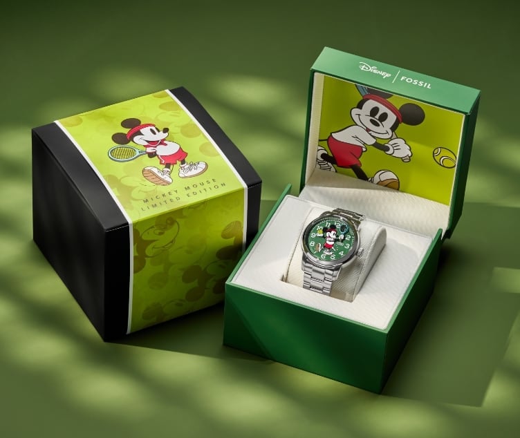 Die Geschenkbox unserer Limited Edition Disney Mickey Mouse Tennis Uhr mit individuellen Micky-Maus-Grafiken. Zwei der Boxen werden nebeneinander angezeigt. Die Box links wird mit einer umlaufenden Micky-Grafik gezeigt. Die Box rechts ist geöffnet und zeigt innen die Uhr und die individuelle Micky-Grafik.