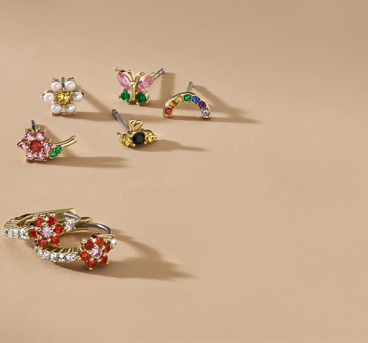 Ein GIF mit Ohrringen und Ringen mit bunten Glassteinen, die an einen Blumengarten erinnern.