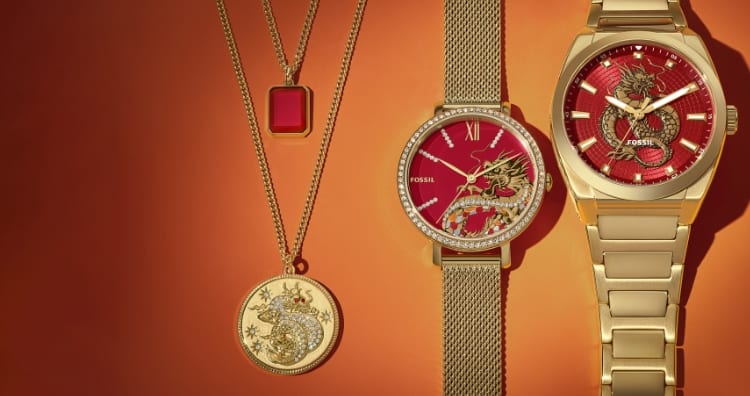 Halskette mit rotem Achatanhänger und Halskette mit goldfarbenem Drachenanhänger. Zwei goldfarbene Uhren, die exklusiv für das chinesische Neujahr designt wurden, mit roten Zifferblättern und Drachendetails. Goldfarbene Drachengrafik.