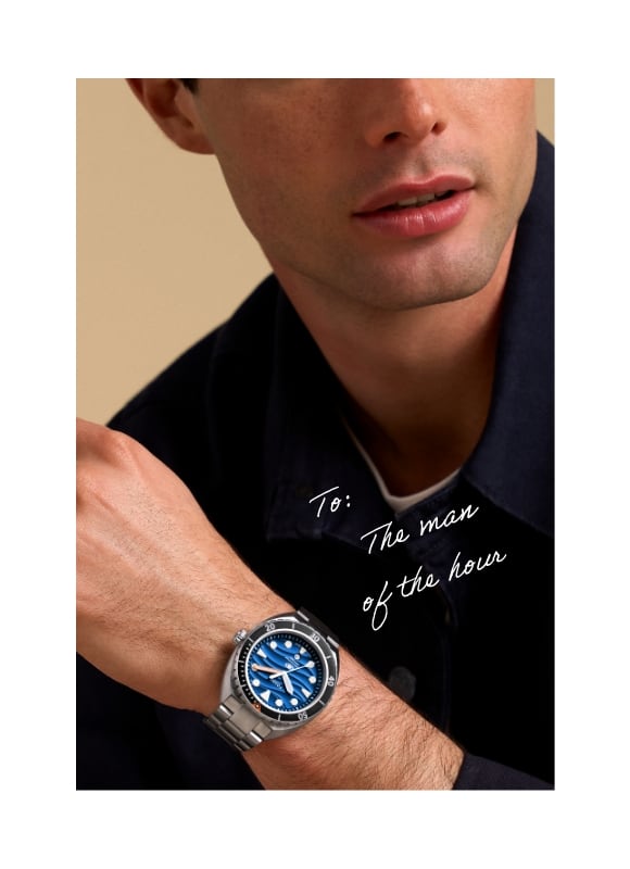 Un homme portant la montre Breaker Dive en acier inoxydable avec un cadran bleu. Texte manuscrit - « To : The man of the hour »