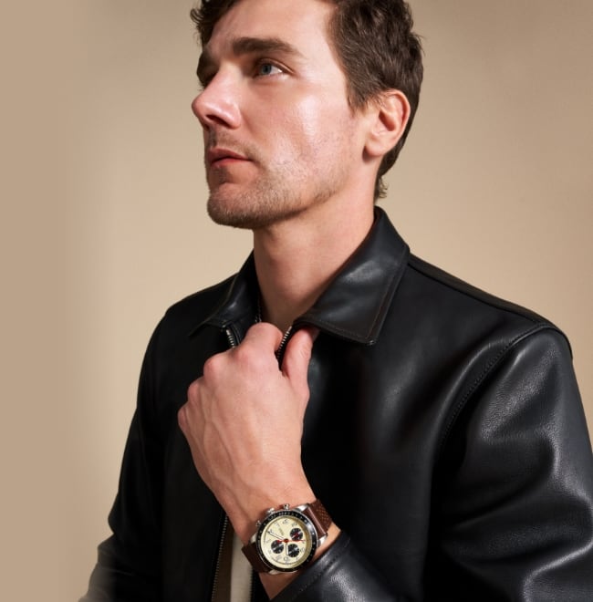 Un homme portant une veste en cuir et la montre Sport Tourer avec bracelet en cuir brun.