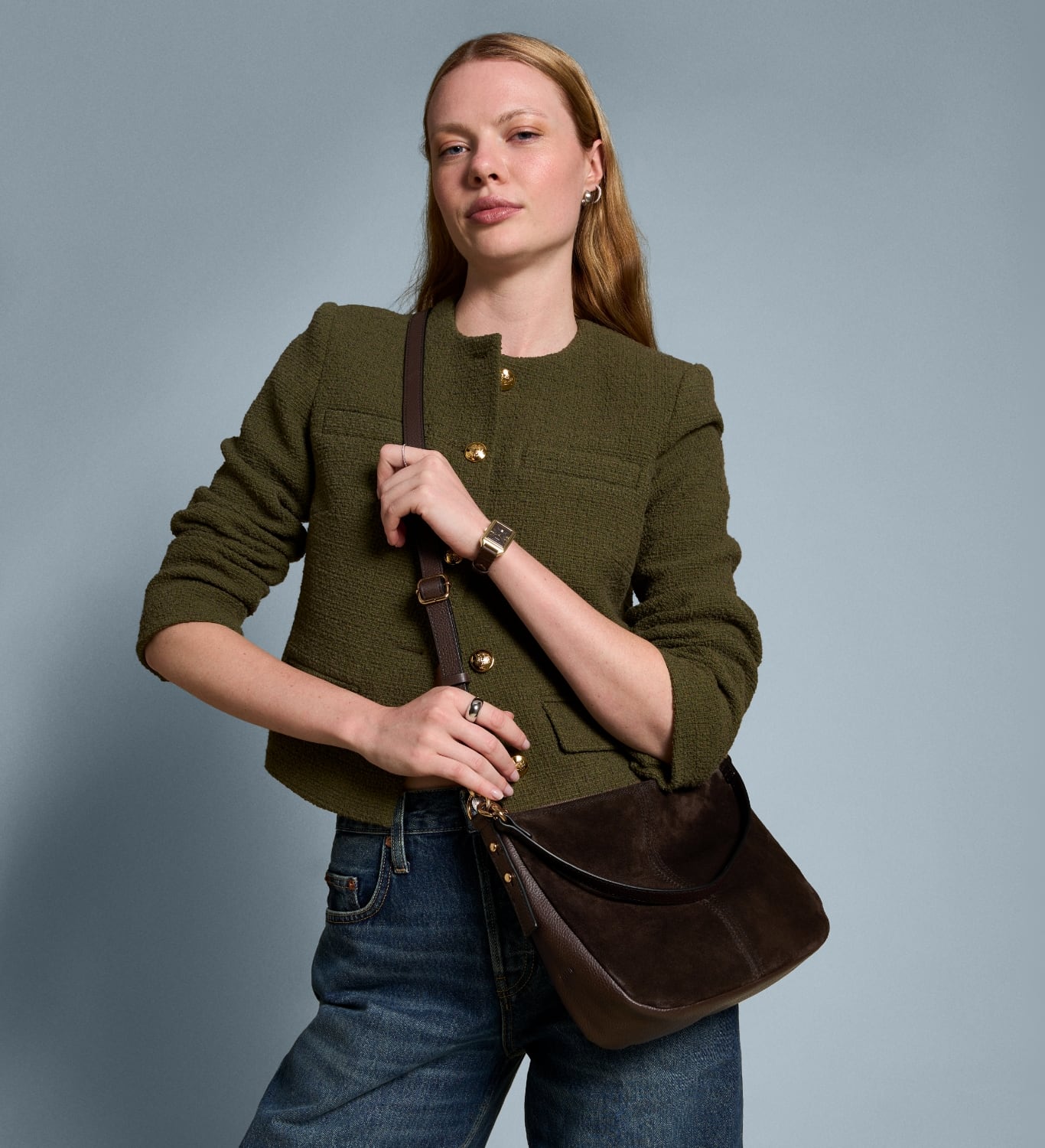 A woman wearing a brown leather Jolie crossbody bag.
