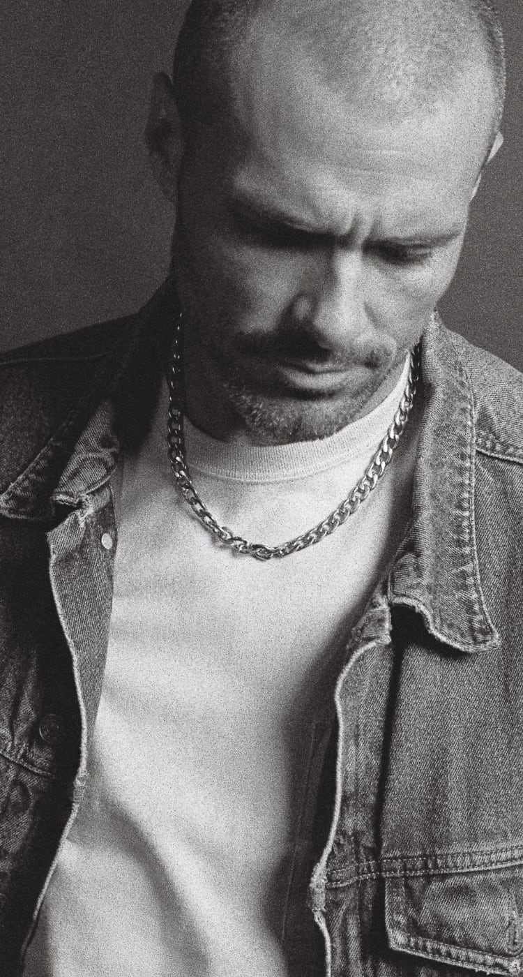 Black-and-white images of a man wearing a chain necklace and bracelet.