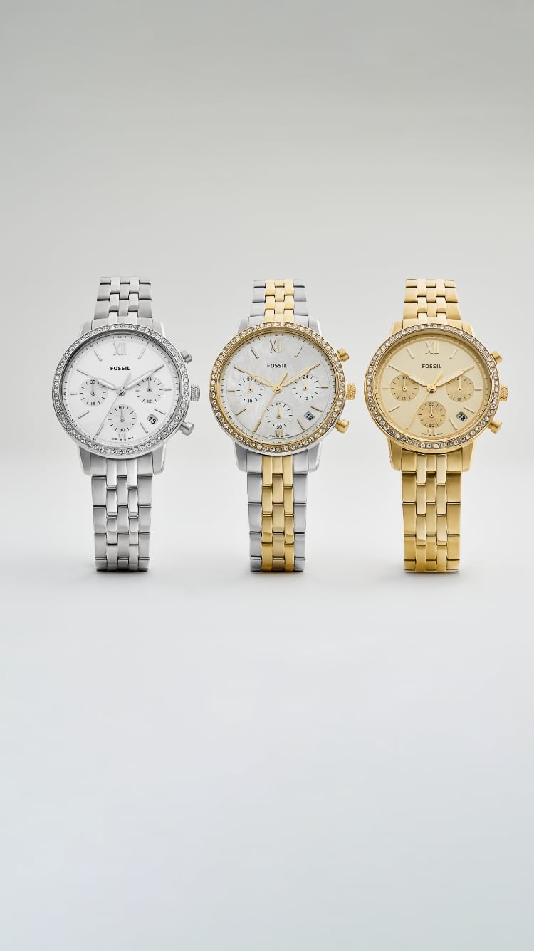 Trois montres pour femme, une argentée, une bicolore et une dorée sur un fond gris.