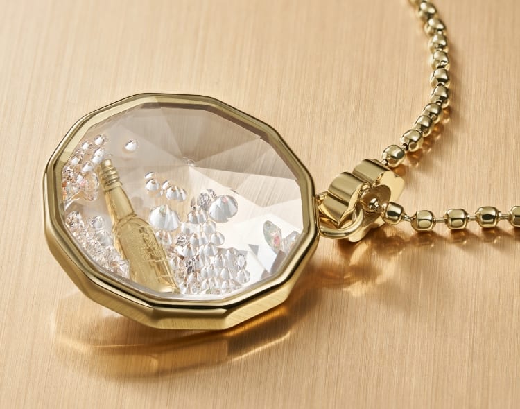 Un collier ton or avec des cristaux à facettes mettant en vedette une boisson revigorante pétillante.